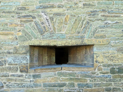 Stone arrow slit with a decorative archway above it