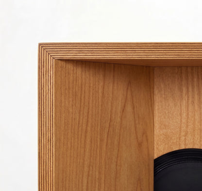 Close-up of a wooden speaker enclosure with a white background